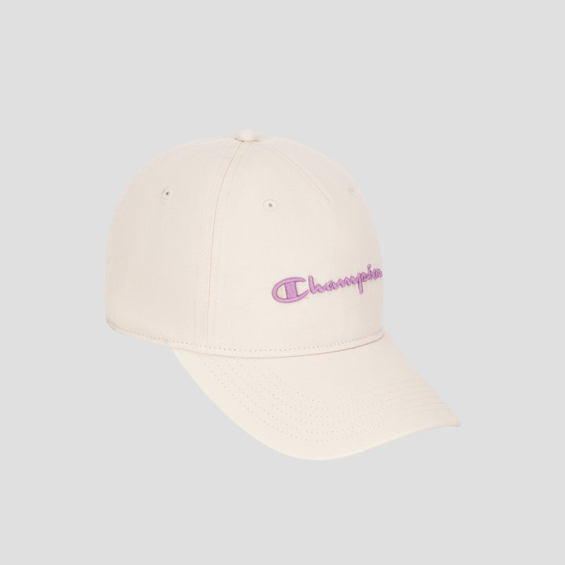 A Script Embroidery Adjustable Cap by Champion, in beige washed cotton twill, features a curved brim and the signature purple Champion logo embroidered on the front, shown against a plain gray background.