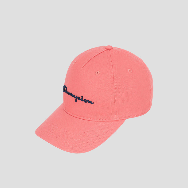 A coral pink Champion Script Embroidery Adjustable Cap in washed cotton twill, featuring black embroidered text on the front, displayed on a light gray background.
