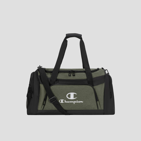 The Champion Stadium Duffel Bag is shown in olive green and black, featuring dual handles, a shoulder strap, front zip pocket, side pockets, and a prominent white Champion logo on the front, set against a plain gray background.