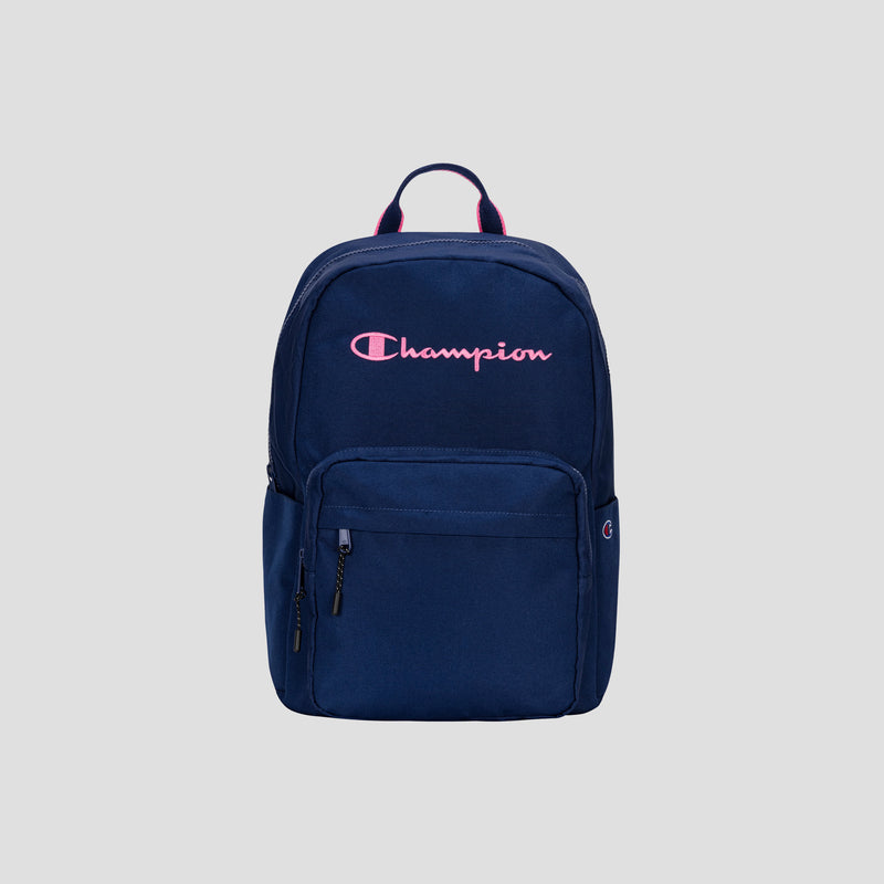 A Champion Steady Backpack in navy blue featuring a front zip pocket and a pink Champion logo on the upper front, shown against a plain gray background. Ideal for daily use or as a laptop backpack for travel.