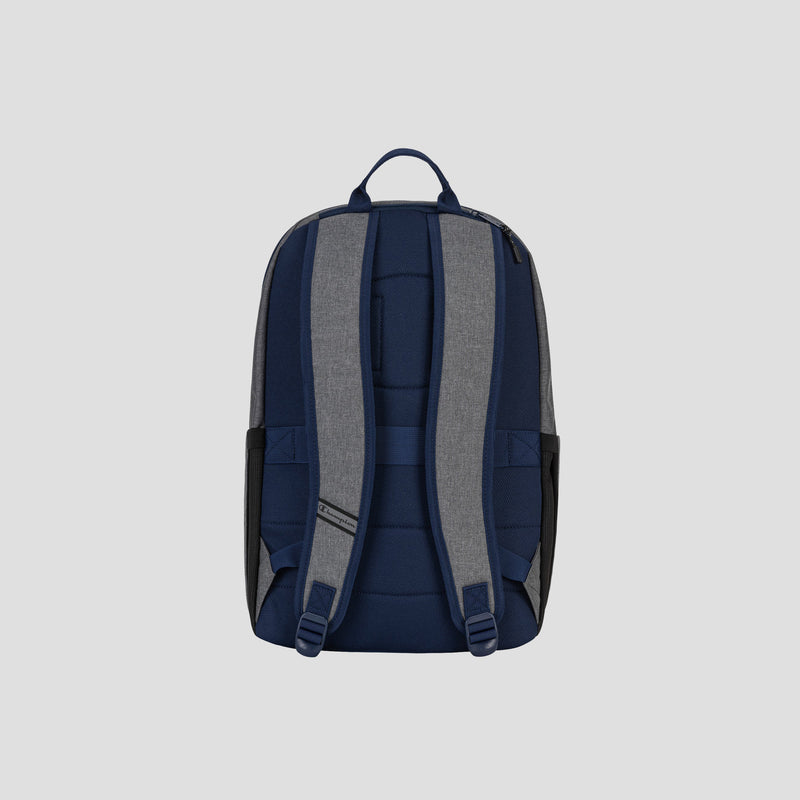 The Champion System Backpack is displayed from the back in blue and gray, highlighting its padded shoulder straps, top handle, and side pockets against a plain light gray background. Designed with multiple storage compartments and a padded laptop sleeve, the System Backpack provides both organization and comfort for everyday use.