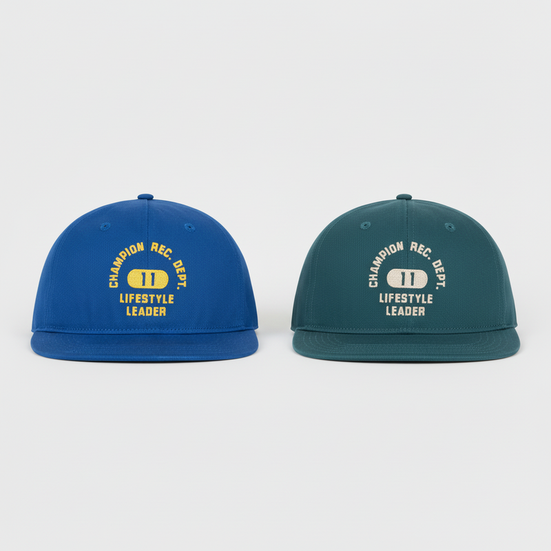 The Champion Athletic Dept Flat Brim Cap 2 Pack includes a blue and a dark green cap, each with "CHAMPION REC. DEPT. LIFESTYLE LEADER" text and a yellow-and-white "1" emblem on the front.
