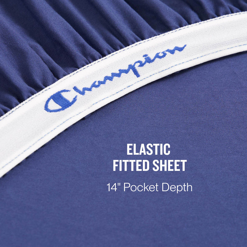 Close-up of the Champion Elastic Logo Microfiber Sheet Set in blue, featuring a branded band and elastic edges. Text below reads: ELASTIC FITTED SHEET 14” Pocket Depth. Crafted from washed microfiber, this set combines comfort and durability.