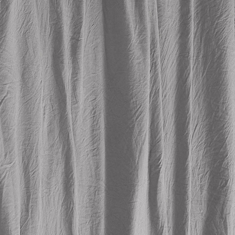 Close-up of light gray, wrinkled fabric with vertical folds and soft shadows, creating a textured and slightly uneven surface—characteristic of the Champion Embroidery Patch Microfiber Sheet Set.