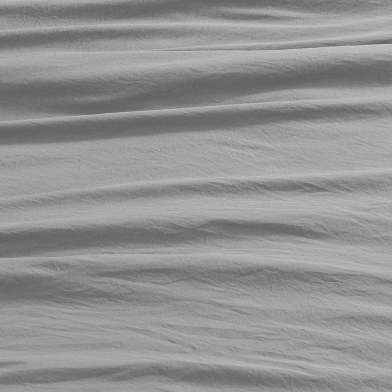 Soft light gray microfiber fabric from the Champion Peak Comfort Microfiber Sheet Set, featuring multiple horizontal wrinkles and creases that create a subtly textured, slightly uneven surface. The image highlights the natural folds typical of quality athletic bedding, showcasing comfort and simplicity without any distinct patterns or objects.
