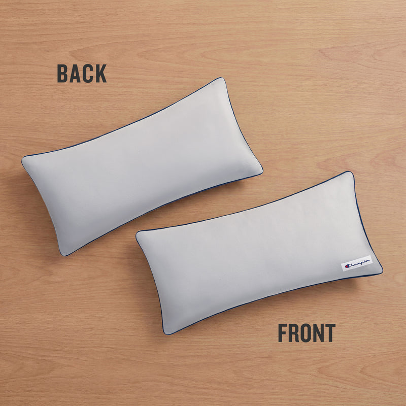 Two Champion Faux Wool Body Pillows rest on a wooden surface, labeled BACK and FRONT. The front pillow showcases a small Champion logo tag in the corner and is filled with plush polyester for superior comfort, while the back pillow remains plain.