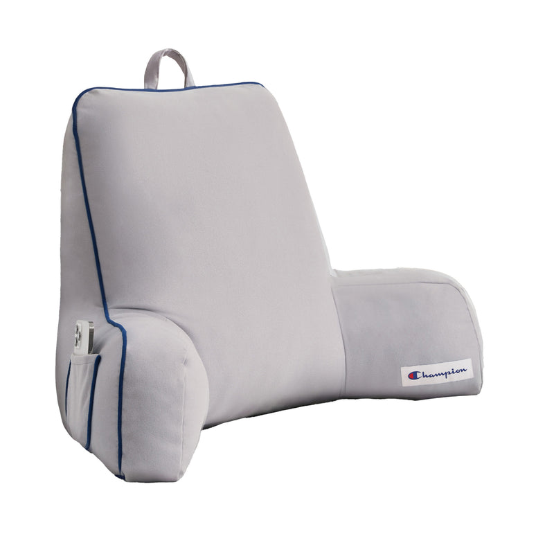 The Champion Faux Wool Backrest Pillow features supportive arms, a light gray color with blue trim, and a Champion logo patch. Designed for comfort with soft faux wool, it includes a convenient top carrying handle and a small side pocket for holding a white remote.