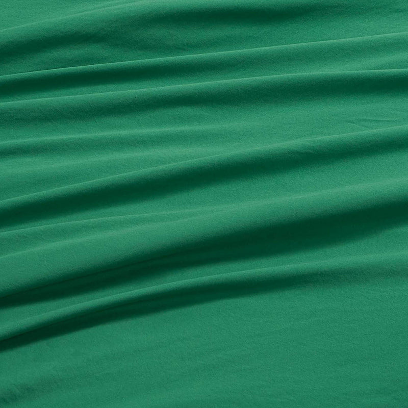 Champion’s Elastic Logo Microfiber Sheet Set in green features a smooth, soft texture with several horizontal folds and wrinkles that create a distinctive, draped appearance. The microfiber material displays gentle shading and a plush feel, enhancing the set’s textured look.