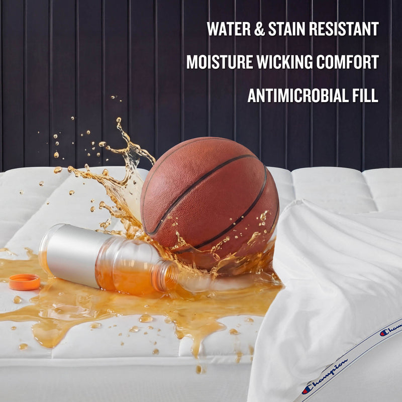 A basketball and spilled drink rest on a bed featuring Champion’s Ultimate Protection Mattress Pad with bedding. Text reads: Water & stain resistant, moisture wicking comfort, antimicrobial fill.