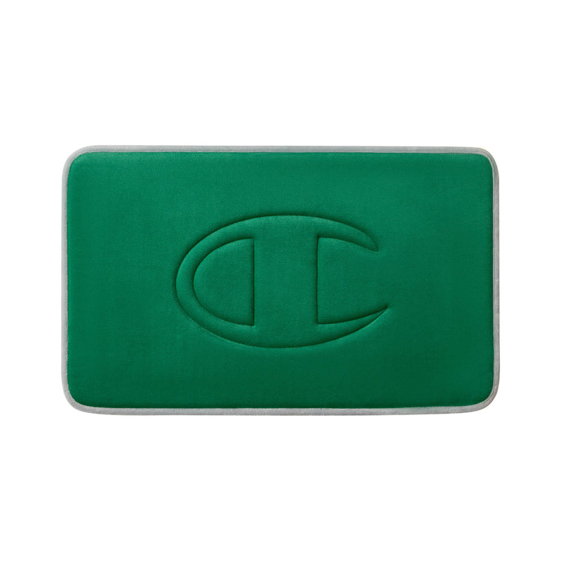 A rectangular green Champion Quilted Logo Memory Foam Bath Mat with rounded corners, featuring an embossed, stylized “C” logo in the center.