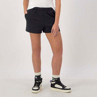 Person wearing black shorts and black sneakers on a white background