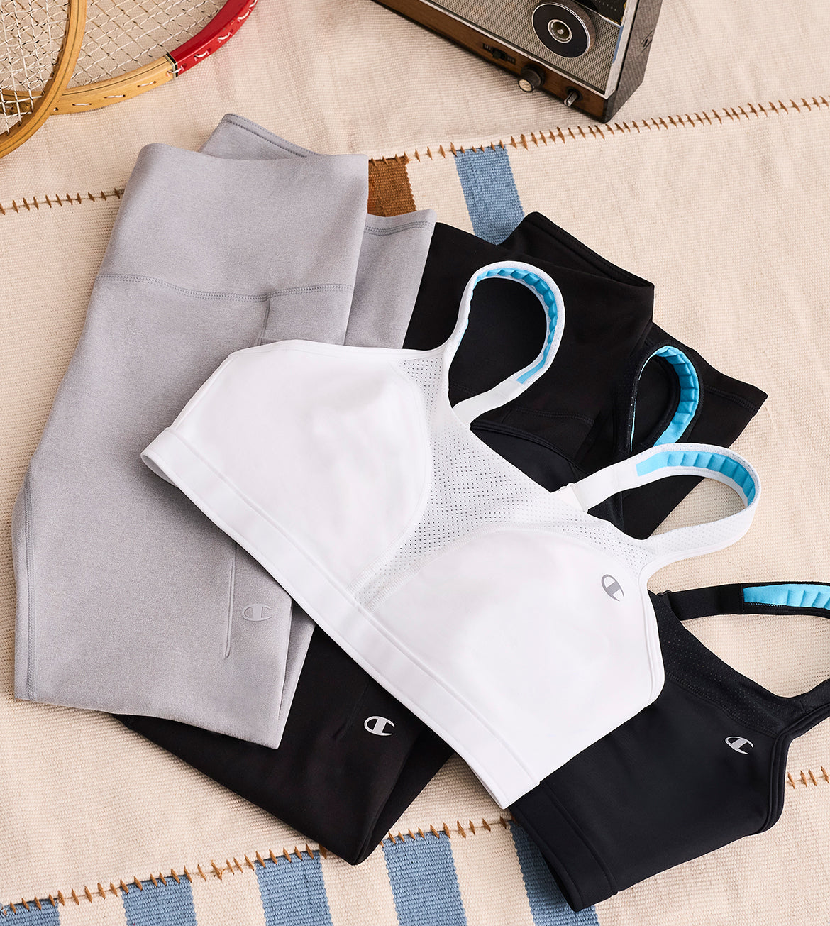 Stack of folded pants and sports bras on a textured surface with a vintage-style background.