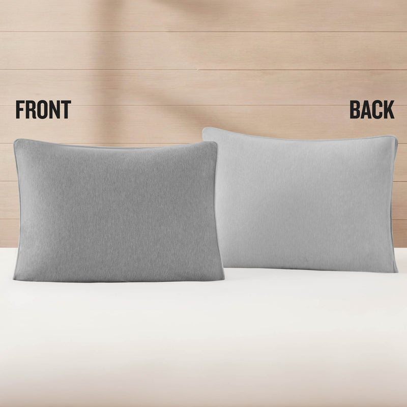 Two gray pillows are displayed on a bed, one labeled FRONT and the other BACK, set against a light wooden wall background—perfect for pairing with an athletic bedding look like the Champion Premium Reversible Solid Jersey Comforter Set.