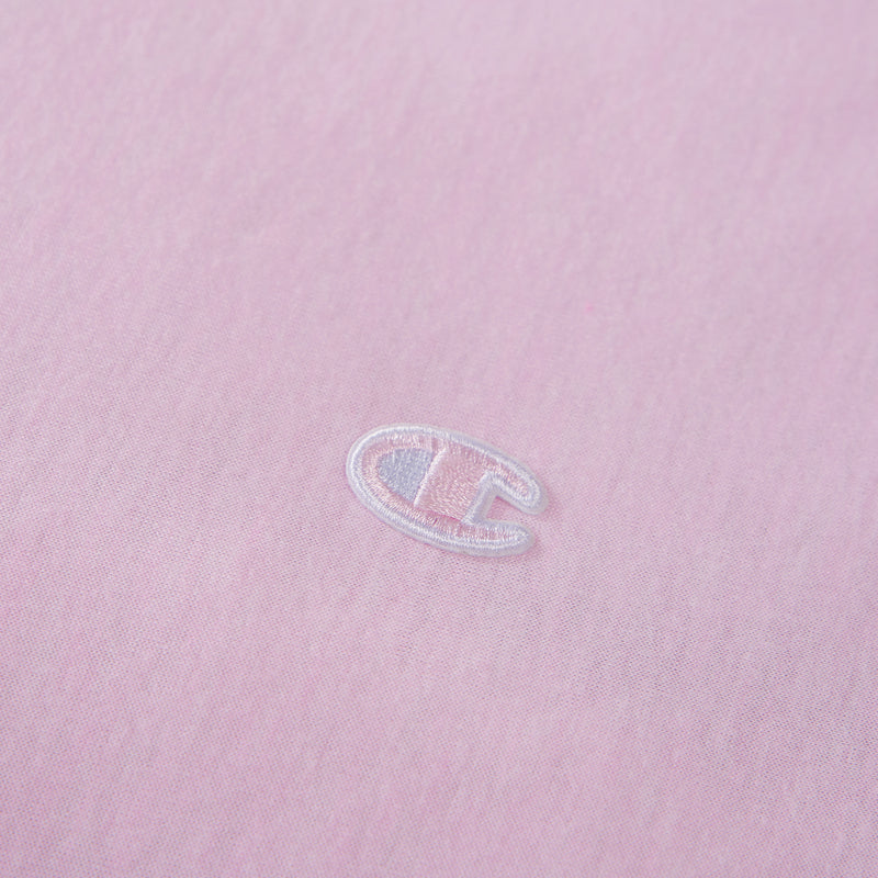 Close-up of a light pink fabric with a small, white embroidered C logo near the center, representing the Champion brand—an ideal accent for those looking to add a stylish touch to their Champion Reversible Solid Jersey Comforter Set.