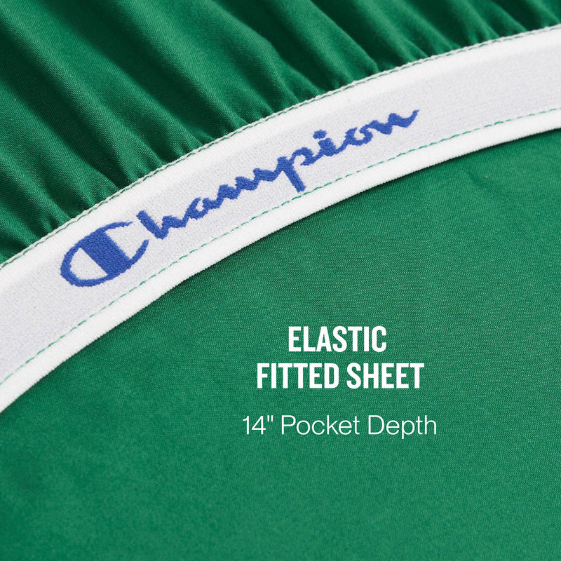 Close-up of a green elastic fitted sheet from the Champion Elastic Logo Microfiber Sheet Set, featuring “Champion” in blue on the white elastic band. Text on the sheet reads: ELASTIC FITTED SHEET 14 Pocket Depth.