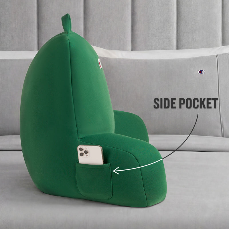 A Champion Jersey Backrest Pillow in green is displayed on a gray bed with pillows. The plush lounge chair features armrests and a side pocket, which is shown holding a smartphone. A label points to the pocket and reads SIDE POCKET.